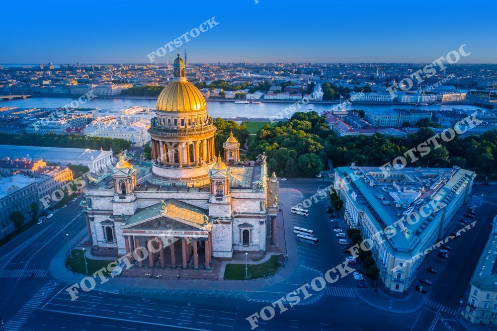 Панорамная фотография Санкт-Петербурга с высоты птичьего полета, на которой виден Исаакиевский собор, исторические улицы и архитектурные ансамбли центра города. Съемка с дрона позволяет оценить масштабы городской застройки, гармонию между зданиями и городскими магистралями, а также уникальные панорамные виды Северной столицы России. Фотография передает атмосферу величия архитектуры Петербурга, красоту улиц и куполов собора, а также историческое наследие города. Снимок идеально подходит для туристических публикаций, фотостоков, оформления интерьеров, рекламы и материалов о достопримечательностях Санкт-Петербурга.